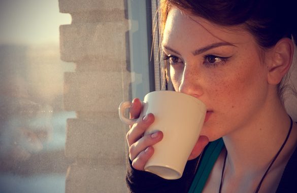 Beautiful-young-woman-in-casual-wear-dreaming-with-cup-of-hot-tea-over-window-585×381.jpg