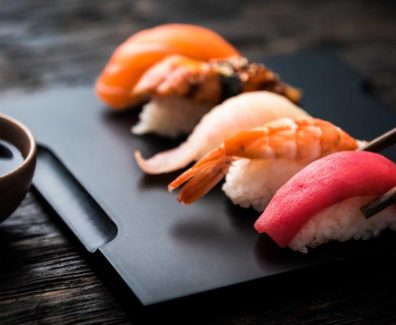 close up of sashimi sushi set with chopsticks and soy on black background