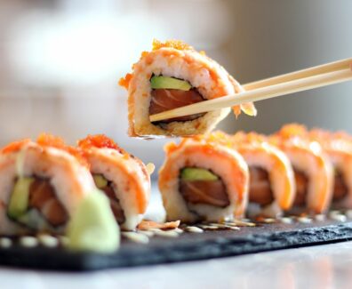 cropped-image-of-person-holding-sushi-at-table-royalty-free-image-691103589-1536344826