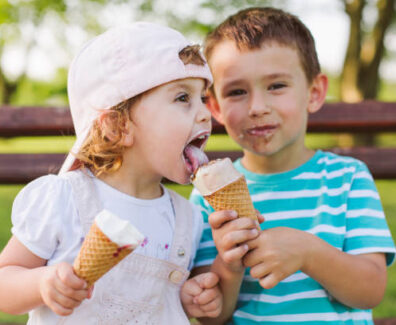 Cute little boy share ice cream with his sister