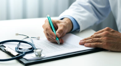 doctor writing documents at desk in clinics office