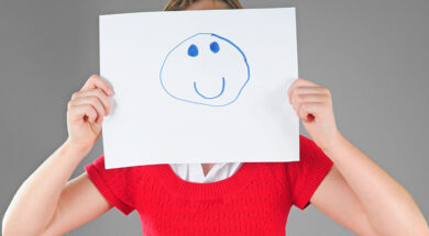 Girl hiding behind happy face