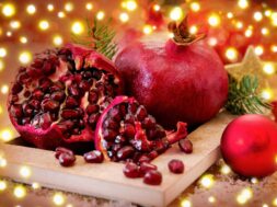 Ripe pomegranates on plate and Christmas decoration.