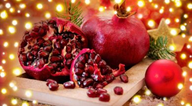Ripe pomegranates on plate and Christmas decoration.