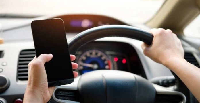 driver-with-phone-696×464
