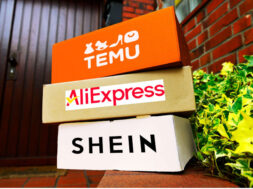 Stacked parcels from the Chinese mail order companies Temu, AliExpress and Shein in a building entrance, photomontage