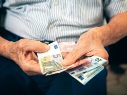 Old man sitting at home counting her money