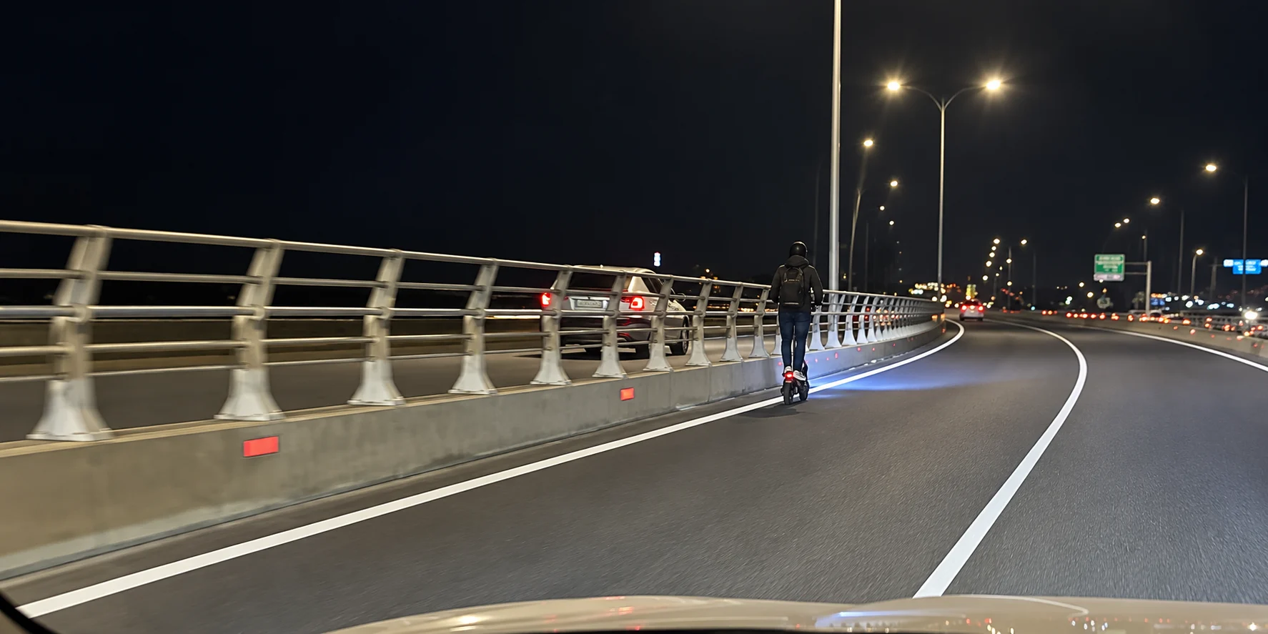nighttime_highway_curve_with_scooter_rider